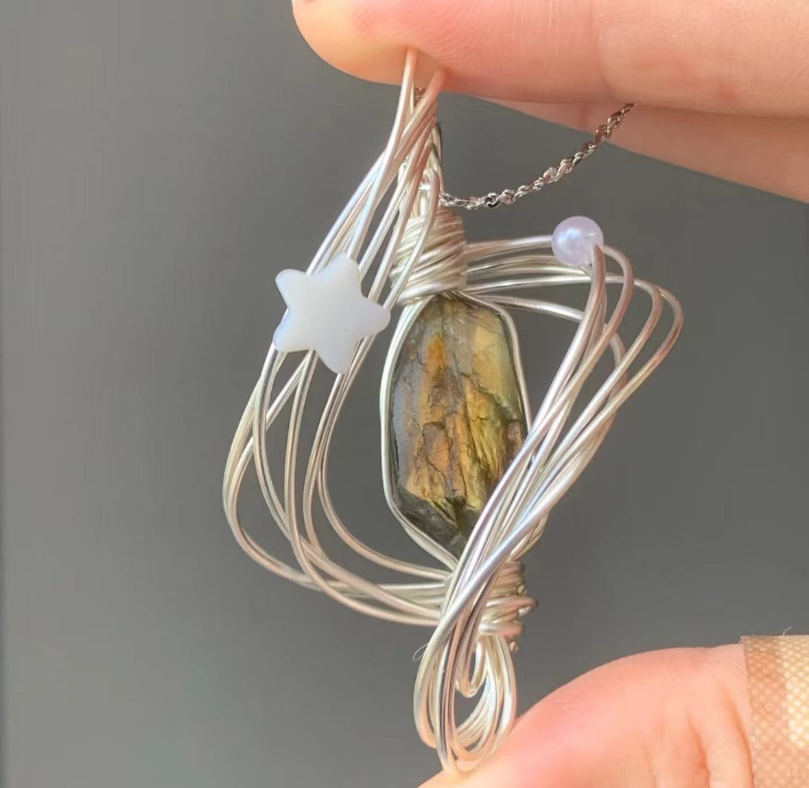 Unique Handcrafted Necklace with Star Accents, Gold Crystal Pendant, and Silver Chain Wound in the Shape of Neptune