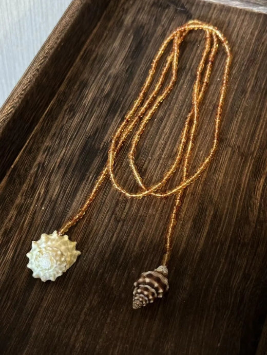 Handcrafted, conch and shells necklace, with amber-colored beads, versatile ways to wear it. The design is unique,makes for a perfect gift