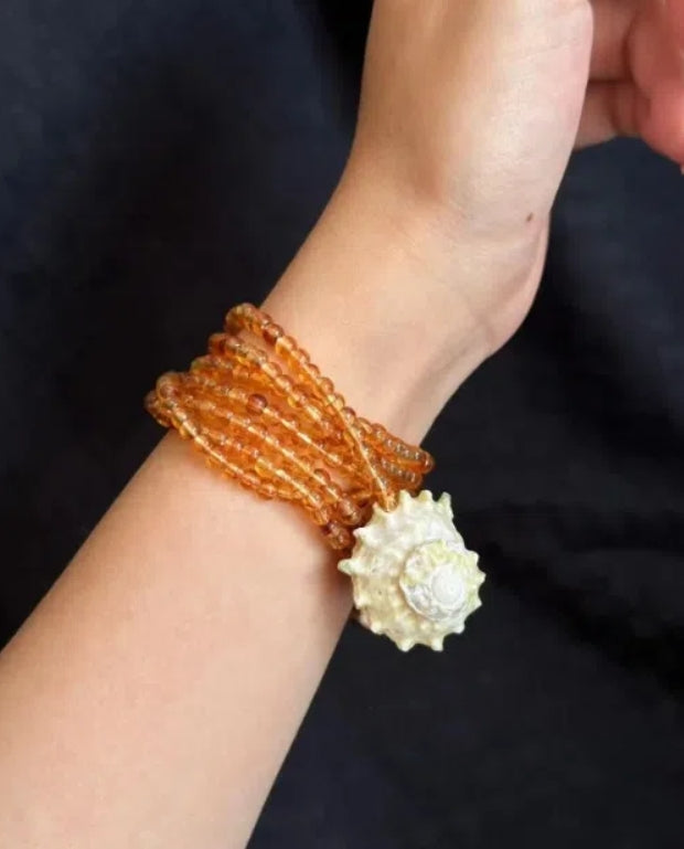 Handcrafted, conch and shells necklace, with amber-colored beads, versatile ways to wear it. The design is unique,makes for a perfect gift