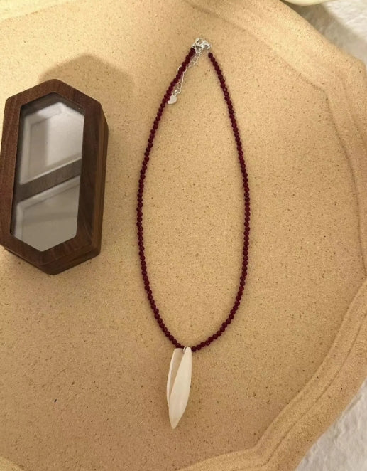 Handcrafted conch pendant with deep red beads necklace,natural conch shells, featuring a simple and exquisite design. It's a perfect gift.