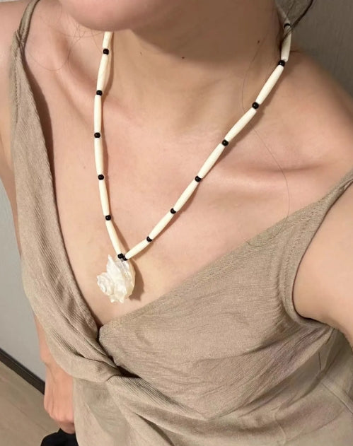 Handcrafted white conch pendant with a black and white chain design, featuring a classic and minimalist aesthetic. It's a perfect gift