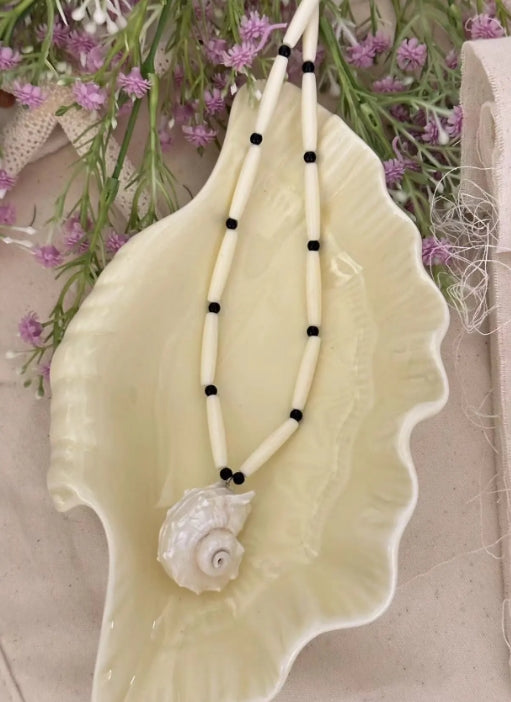Handcrafted white conch pendant with a black and white chain design, featuring a classic and minimalist aesthetic. It's a perfect gift