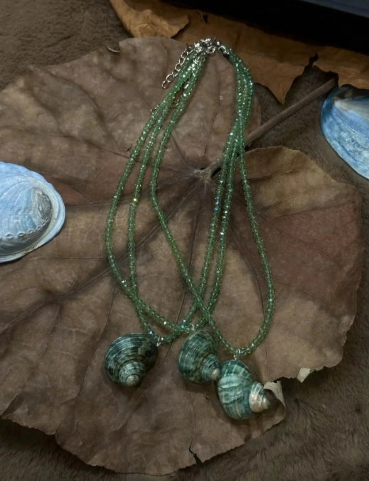 Handcrafted green conch pendant paired with a green beaded necklace, incorporates marine elements and boasts a unique design, perfect gift