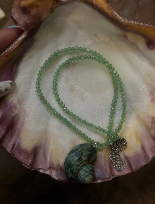Handcrafted green conch pendant paired with a green beaded necklace, incorporates marine elements and boasts a unique design, perfect gift