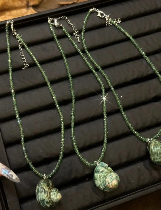 Handcrafted green conch pendant paired with a green beaded necklace, incorporates marine elements and boasts a unique design, perfect gift