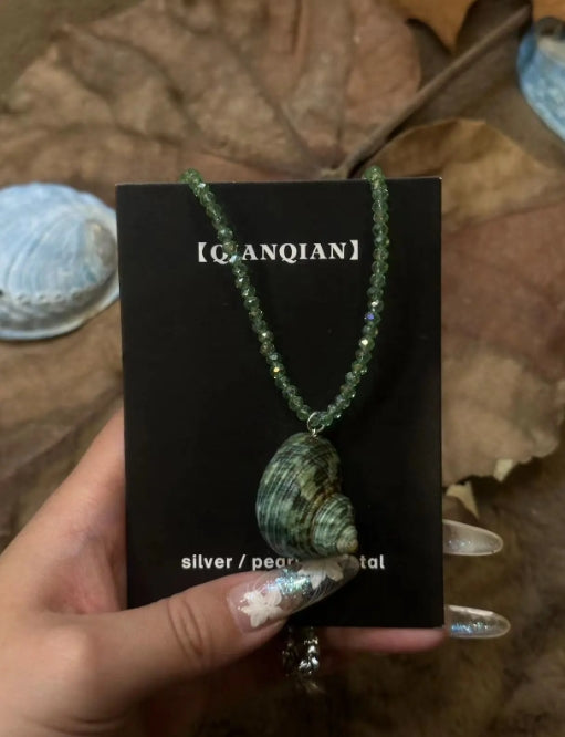 Handcrafted green conch pendant paired with a green beaded necklace, incorporates marine elements and boasts a unique design, perfect gift