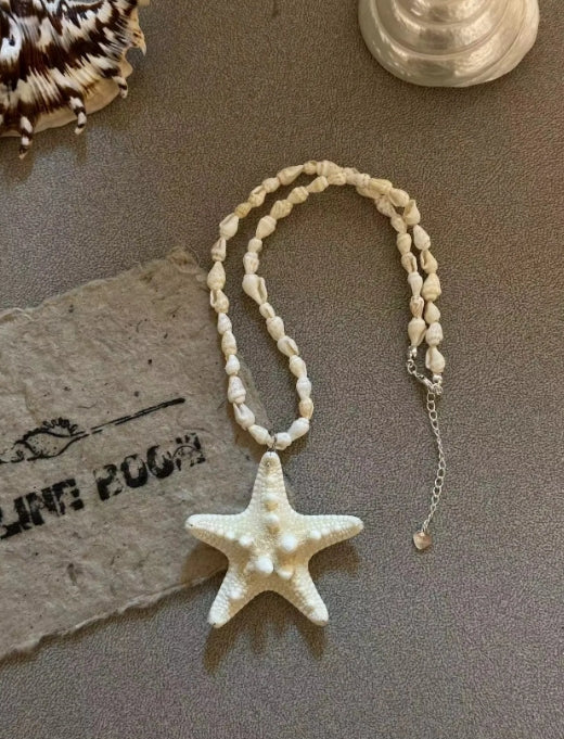 Handcrafted white starfish necklace, composed of small conch shells forming the chain, making it a one-of-a-kind piece. It's a perfect gift