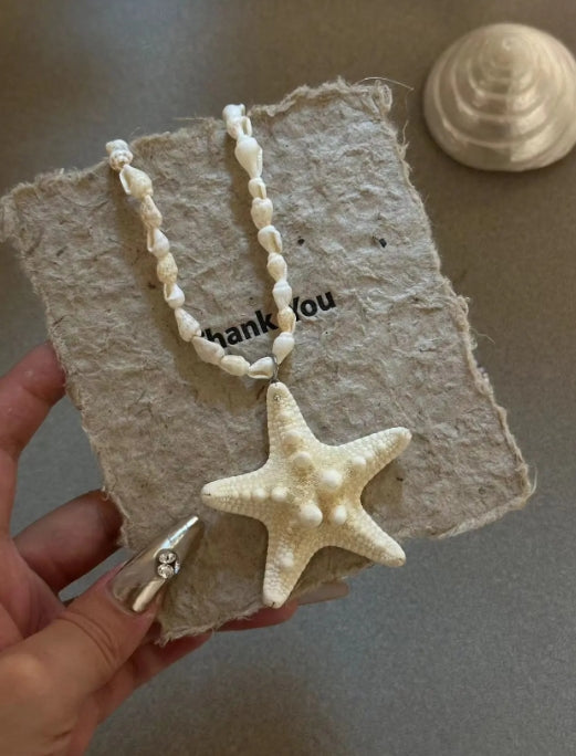Handcrafted white starfish necklace, composed of small conch shells forming the chain, making it a one-of-a-kind piece. It's a perfect gift