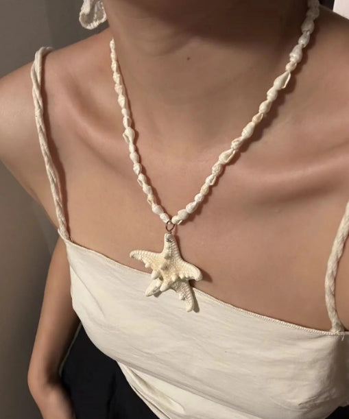 Handcrafted white starfish necklace, composed of small conch shells forming the chain, making it a one-of-a-kind piece. It's a perfect gift