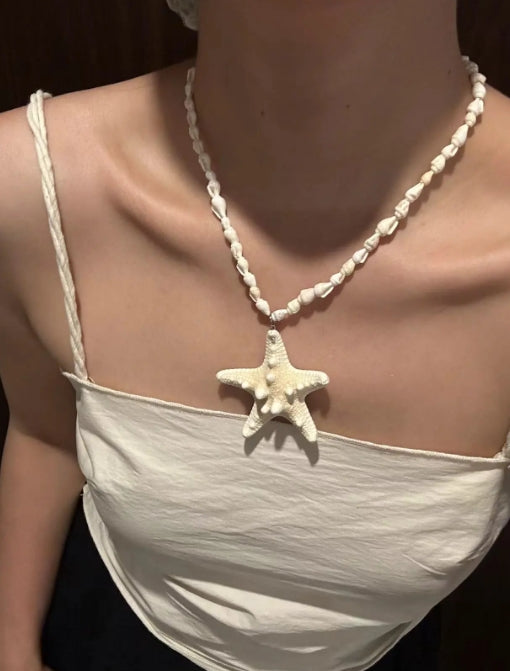 Handcrafted white starfish necklace, composed of small conch shells forming the chain, making it a one-of-a-kind piece. It's a perfect gift