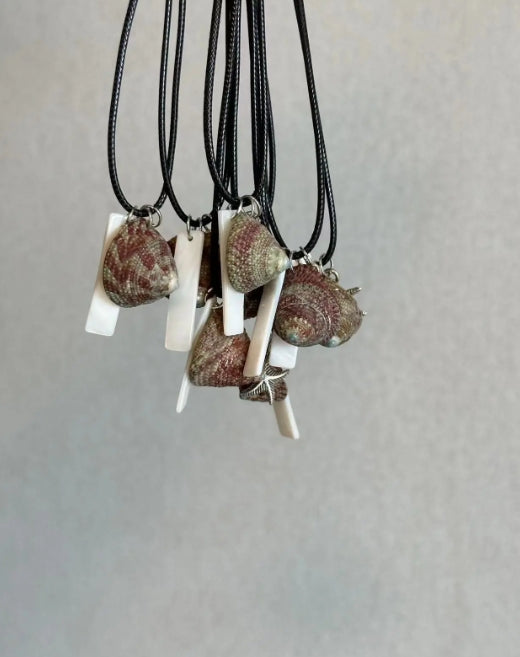Handcrafted necklace with a natural shell pendant and a silver starfish charm, designed with a minimalist approach. It's a perfect gift