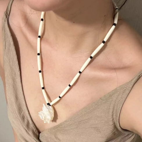 Handcrafted white conch pendant with a black and white chain design, featuring a classic and minimalist aesthetic. It's a perfect gift