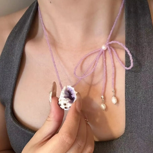 Handcrafted with natural purple conch shells, paired with a purple bow and purple beaded chain, unique and elegant aesthetic,a perfect gift