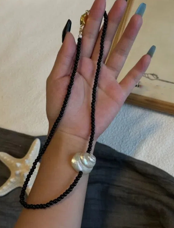 vintage punk-inspired conch necklace with obsidian accents, a Y2Kchoker,  oceanic elements for a unique and niche style