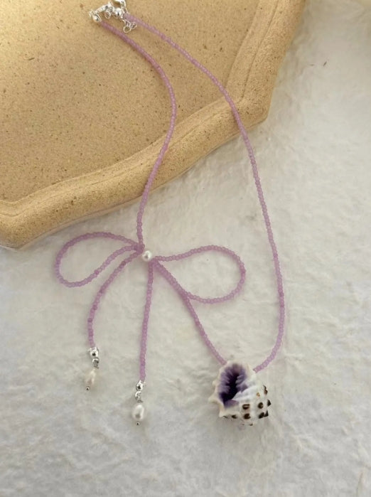 Handcrafted with natural purple conch shells, paired with a purple bow and purple beaded chain, unique and elegant aesthetic,a perfect gift
