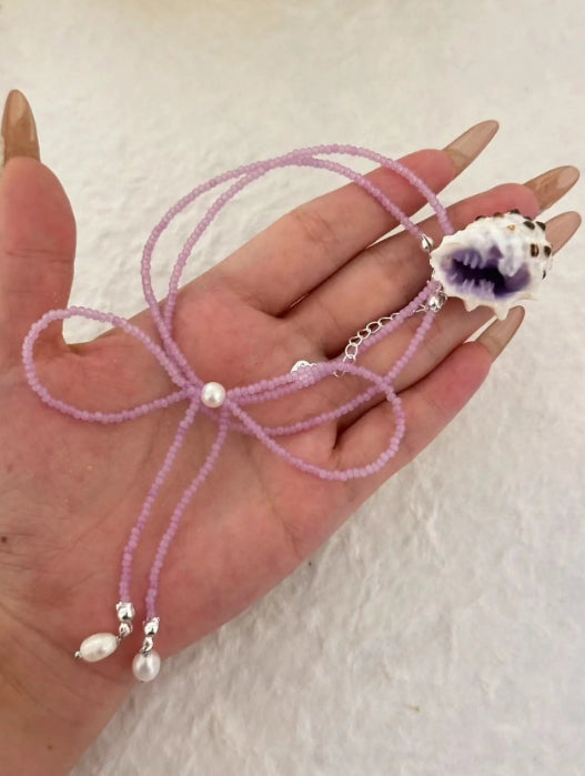 Handcrafted with natural purple conch shells, paired with a purple bow and purple beaded chain, unique and elegant aesthetic,a perfect gift