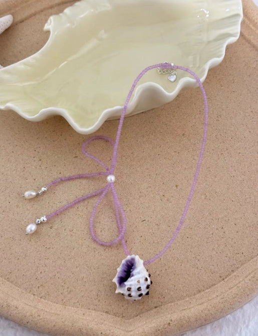 Handcrafted with natural purple conch shells, paired with a purple bow and purple beaded chain, unique and elegant aesthetic,a perfect gift