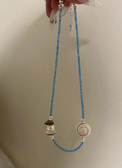 Handcrafted natural shell necklace, paired with a blue beaded strand, designed with a simple and elegant aesthetic,a thoughtful gift for her